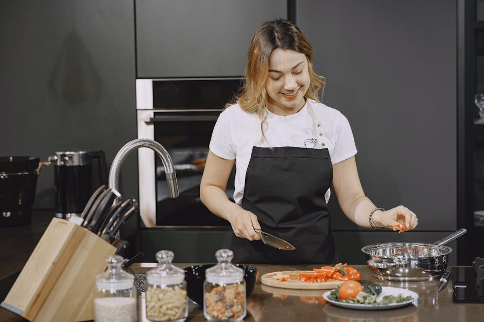 Woman chopping vegetables in a stylish kitchen, captured in warm tones, showcasing food preparation and healthy cooking.