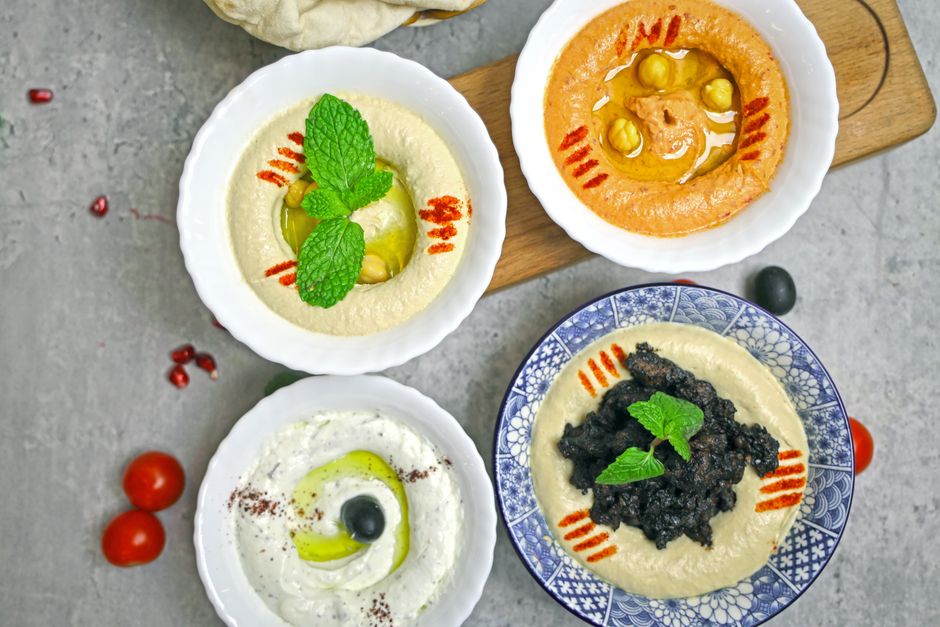 Bowls of hummus and creamy dips on a table