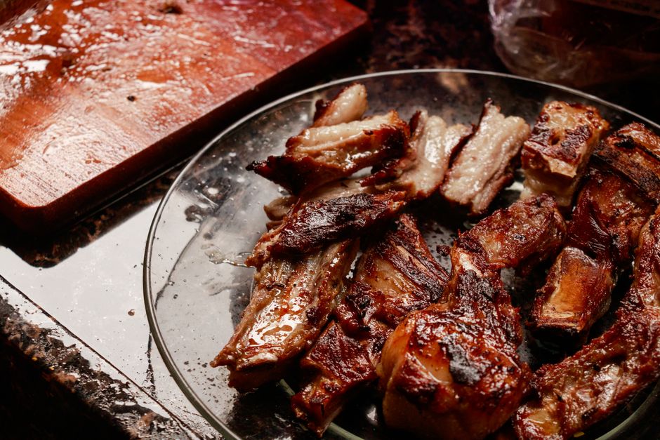 Close-up of mouth-watering grilled meat served on a glass plate, fresh from the barbecue.