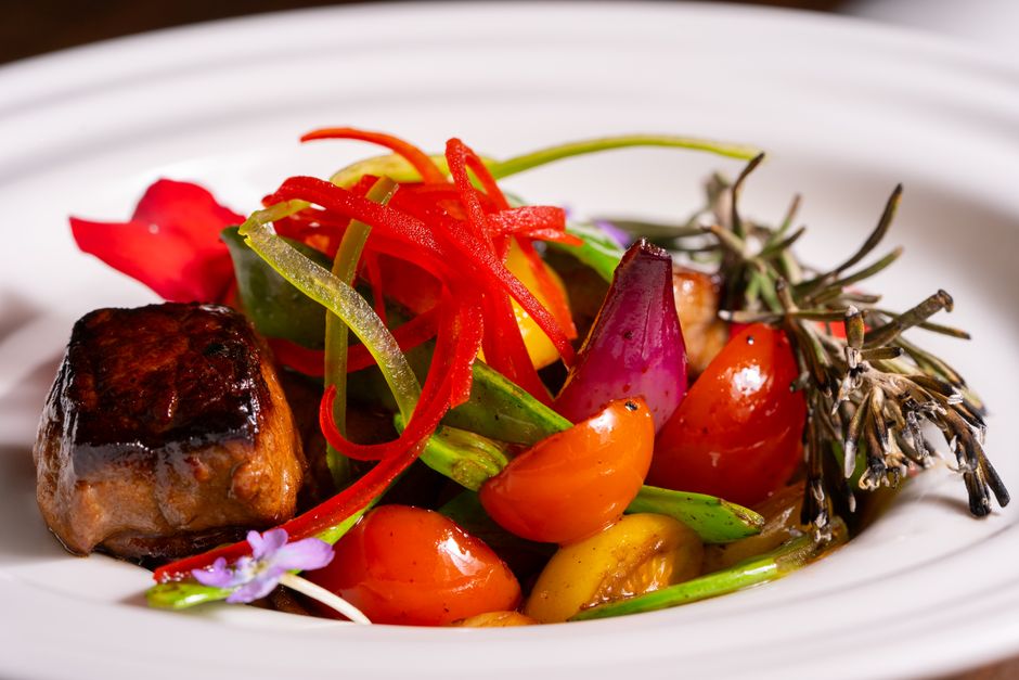 Delicious gourmet dish featuring vibrant vegetables and meat in a white plate, perfect for culinary enthusiasts.