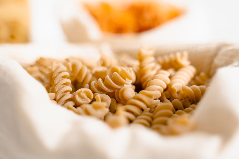 Detailed view of uncooked fusilli noodles wrapped in white fabric, showcasing texture.